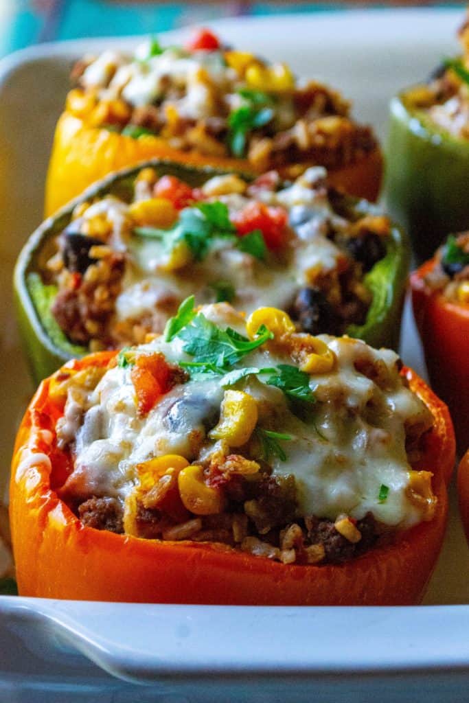 Mexican Stuffed Peppers are made by stuffing colorful bell peppers with ground beef, rice, cheese and all of your favorite Mexican-inspired flavors. The perfect easy weeknight meal, these Mexican Stuffed Peppers are healthy, delicious and a new twist on classic stuffed peppers. | A Wicked Whisk