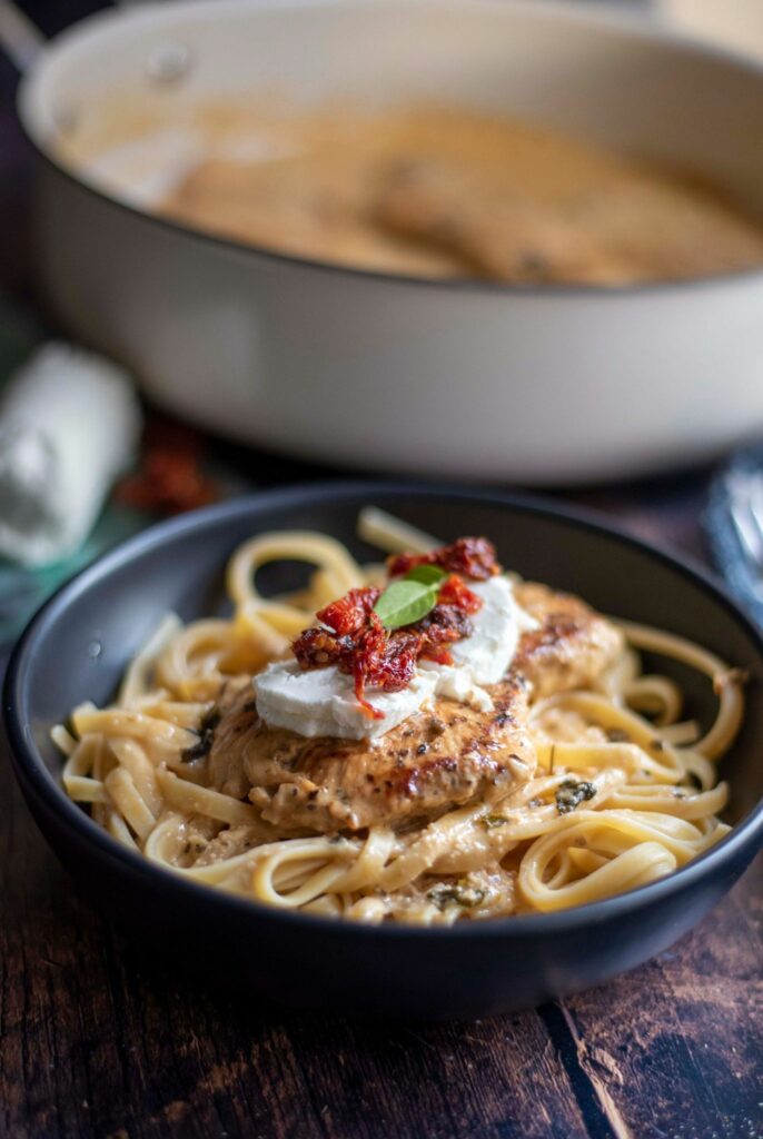 This Chicken Bryan recipe is a Carrabba's copycat that deliverers juicy chicken breast in with a rich garlic lemon butter sauce, covered in sun-dried tomatoes, creamy goat cheese and fresh basil.