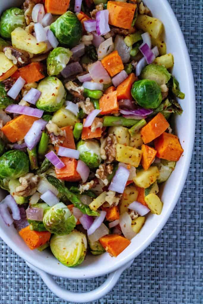Roasted Vegetable Salad with Apple Vinaigrette is the perfect healthy side dish to any meal. Roasted vegetables, apples and walnuts and drizzled with a savory apple vinaigrette, this Roasted Vegetable Salad is an easy holiday side dish to serve up to a hungry crowd.