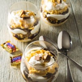 Snickers Peanut Butter Chocolate Parfait | Deliciously decadent layers of peanut butter, chocolate and Snickers candy bars make this Snickers Peanut Butter Chocolate Parfait the perfect dessert! | Pack Momma | htttps://www.awickedwhisk.com