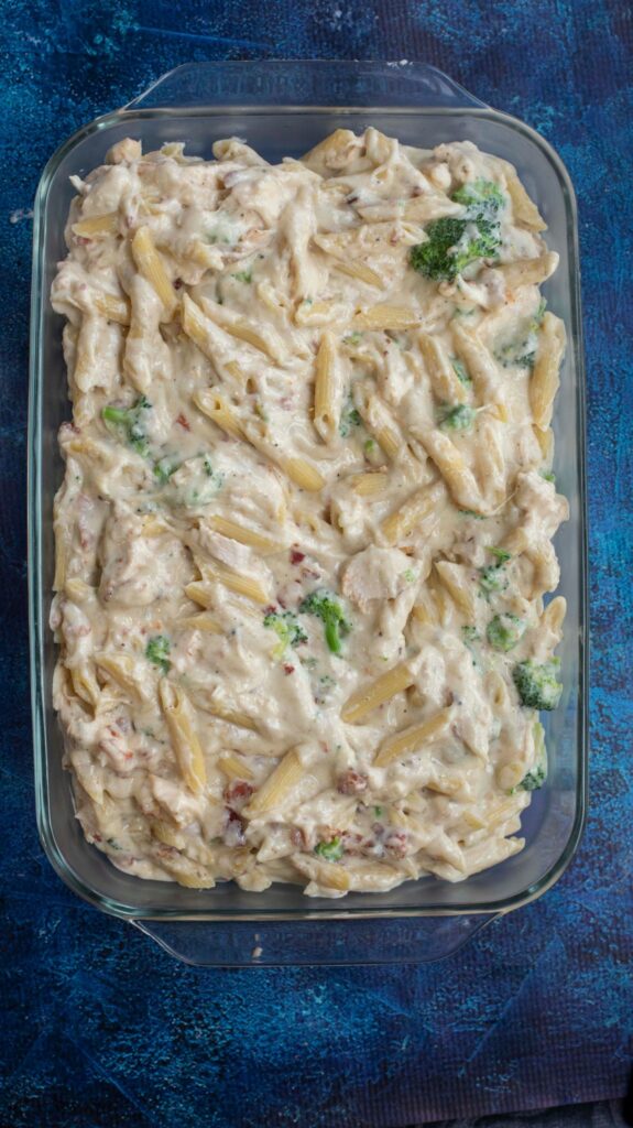 chicken alfredo casserole ingredients mixed together in a pan