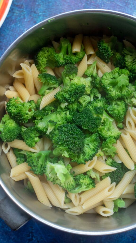 cooked penne pasta and broccoli in a pan