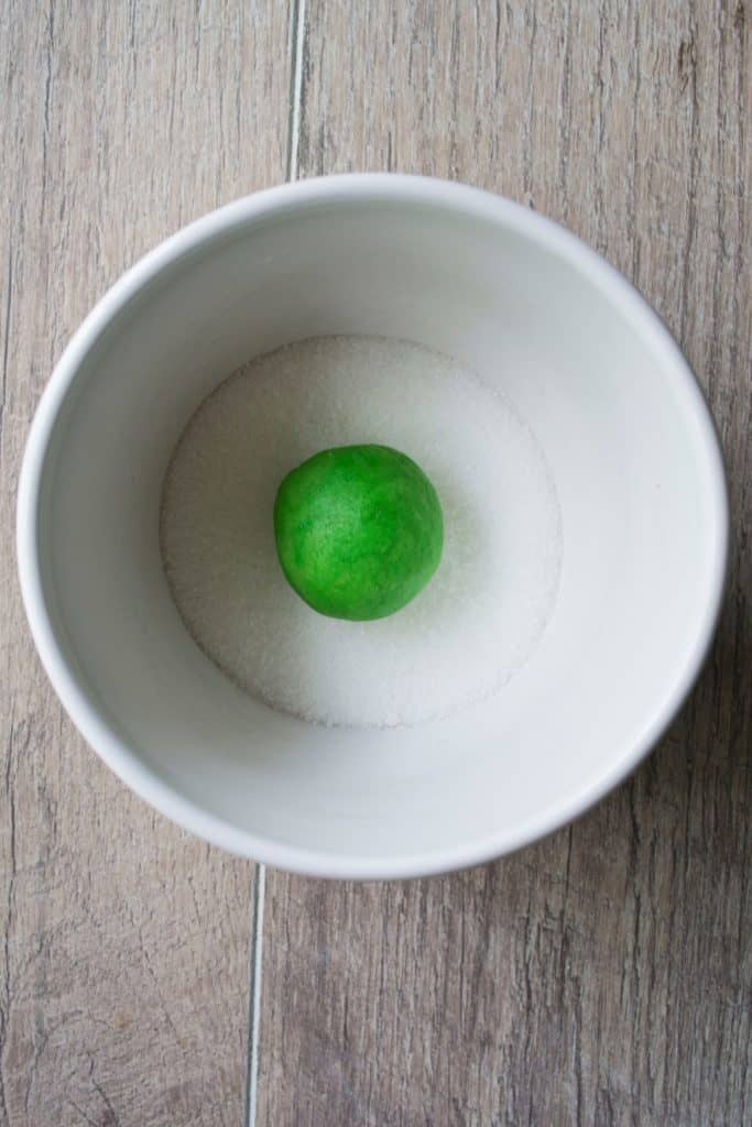 Green Soft Sugar Cookie rolled in a ball and in a bowl of sugar