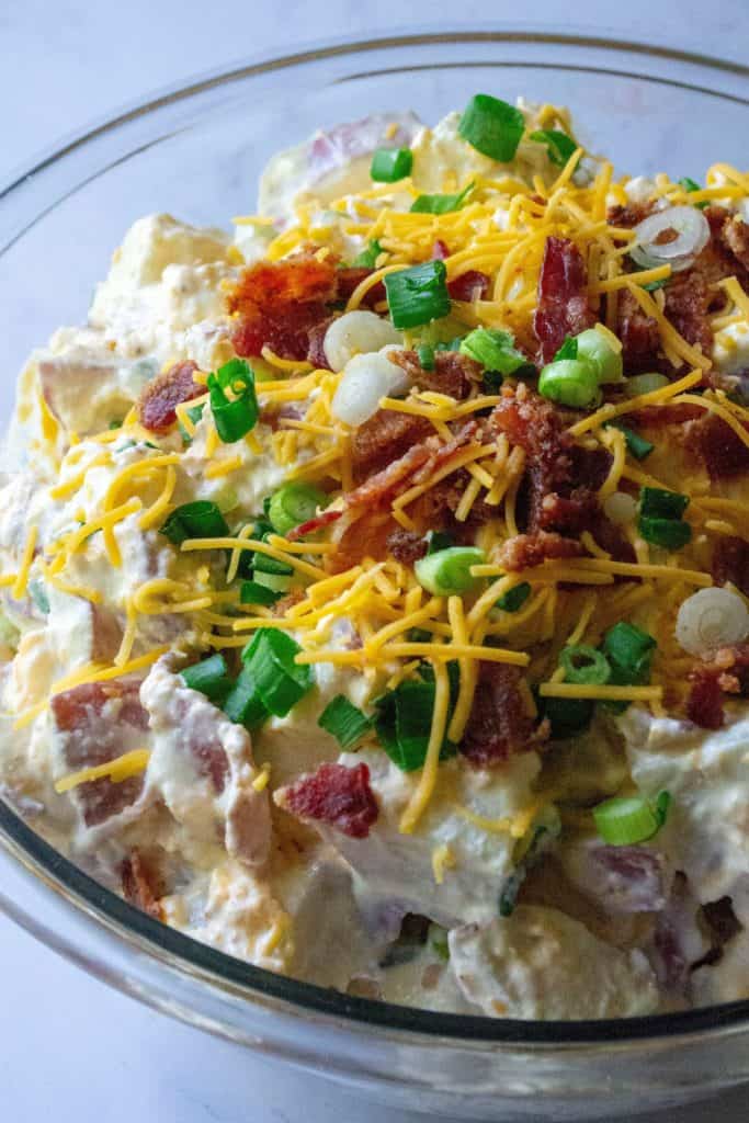 Loaded Potato Salad is tender, creamy red potaotes fully loaded with tons of cheese, bacon and green onions.. The perfect addition to any occasion, this Loaded Potato Salad is the ultimate bbq side dish, pool party snack and summertime dinner table must have!
