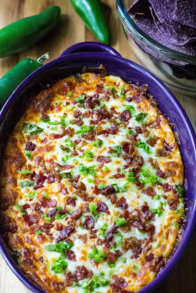 Cheesy Bacon Jalapeno Dip is warm, spicy and loaded with your favorite jalapeno popper flavors.  Easy to make and always a favorite cheesy appetizer, this Cheesy Bacon Jalapeno Dip is the perfect jalapeno dip to feed a crowd.