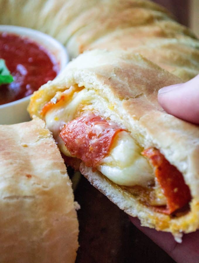 Pepperoni Stromboli Ring is easy to make, packed full of delicious pepperoni pizza flavor and will be your favorite go-to snack to feed a crowd. Perfect for Game-Day tailgaiting parties, holiday get togethers or just Friday night with the family, this Pepperoni Stromboli Ring is always a hit!