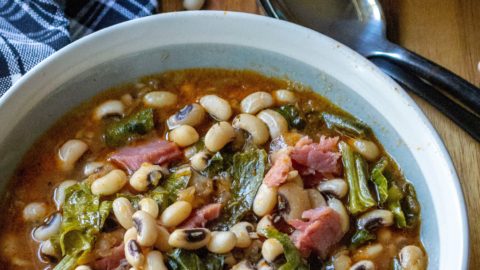 Slow Cooker Black Eyed Peas and Collard Greens is the perfect Southern comfort food to celebrate New Year's Day or ANY day! Made with a leftover ham bone and simmered in a rich tasty broth, these Slow Cooker Black Eyed Peas and Collard Greens are a delicious addition to your New Year's Day menu.