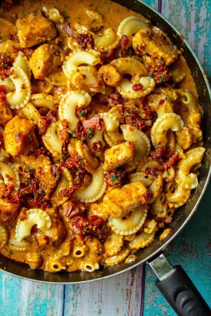 Date Night Sun-Dried Tomato Pesto Pasta is the perfect romantic dinner of tender al dente pasta, spicy Cajun chicken, crispy pancetta all brought together in an easy sun-dried tomato pesto sauce. The perfect "staying in is the new going out" date night dinner in! | A Wicked Whisk