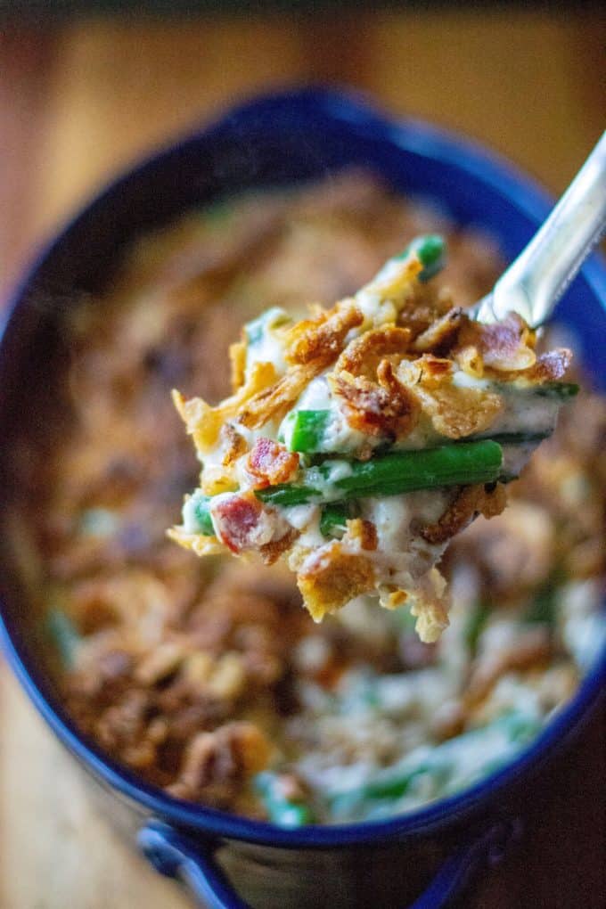 Green Bean Casserole with Bacon is everyone's favorite classic holiday side dish kicked up with tons of mouthwatering flavor. Made with fresh green beans, crispy bacon, topped with French fried onions and melted cheese and no condensed soup, this Green Bean Casserole with Bacon is the perfect easy side dish any night of the week. | A Wicked Whisk