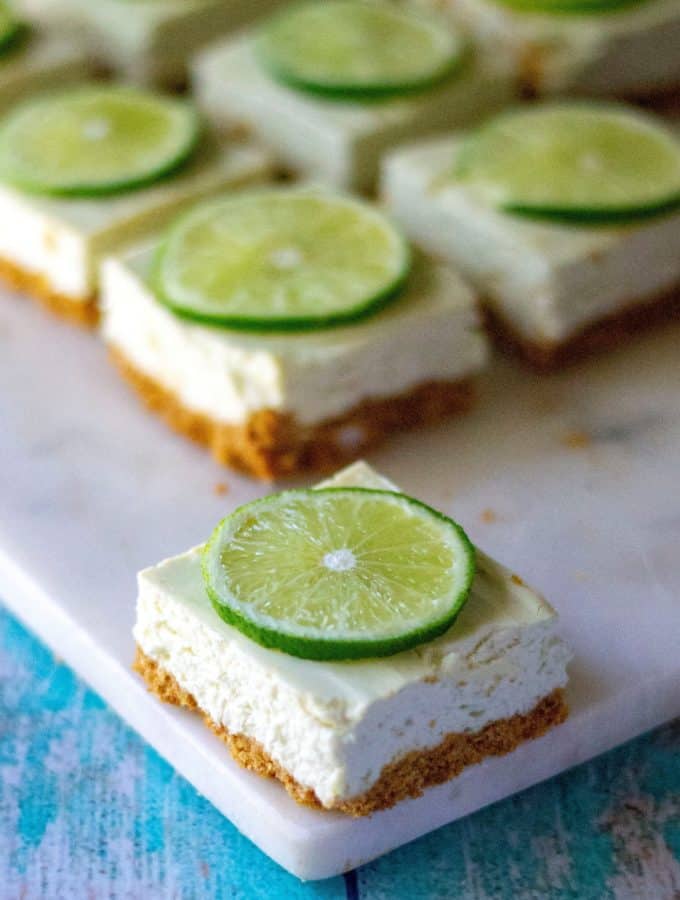 Key Lime Cheesecake Bars are creamy, low sugar and taste just like your favorite key lime pie cheesecake! Made with greek yogurt, fresh key limes and cream cheese, these Key Lime Cheesecake Bars are the perfect easy summer desserts. | A Wicked Whisk