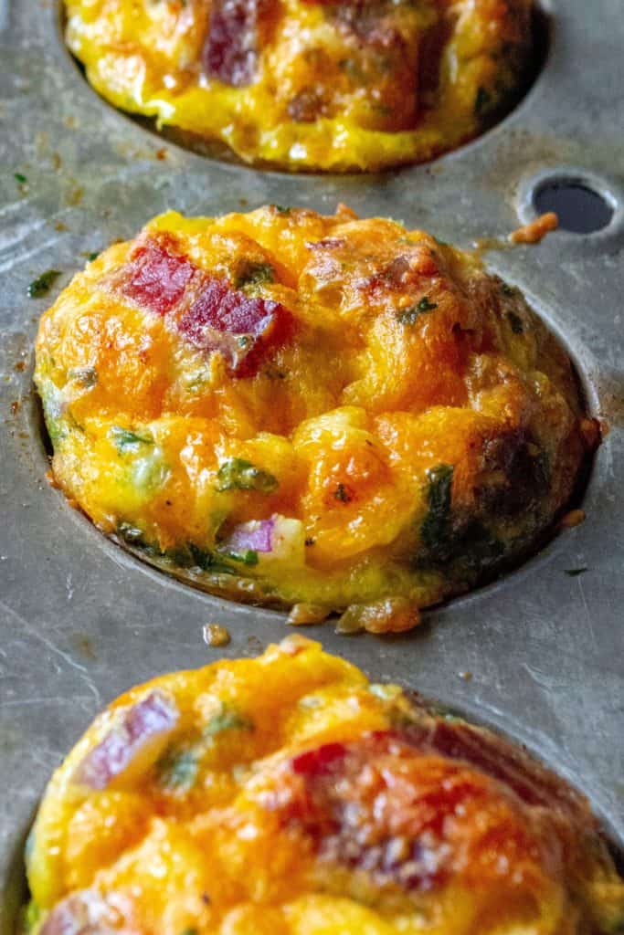 Keto Bacon Egg Muffins are low in carbs and high in protein and packed with tons of bacon, cheese and sausage.  The perfect muffin tin eggs, these Keto Bacon Egg Muffins are fun to make, super tasty and the best easy low-carb keto breakfast on the go. | A Wicked Whisk