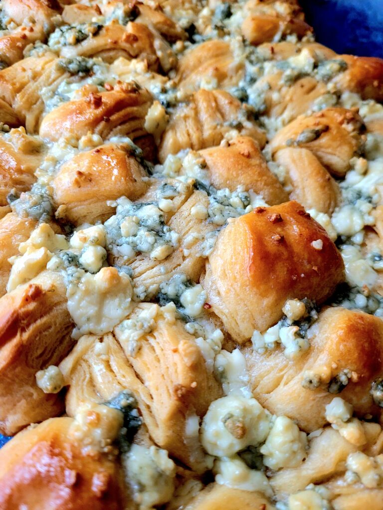 pan of blue cheese biscuits covered in crumbled blue cheese