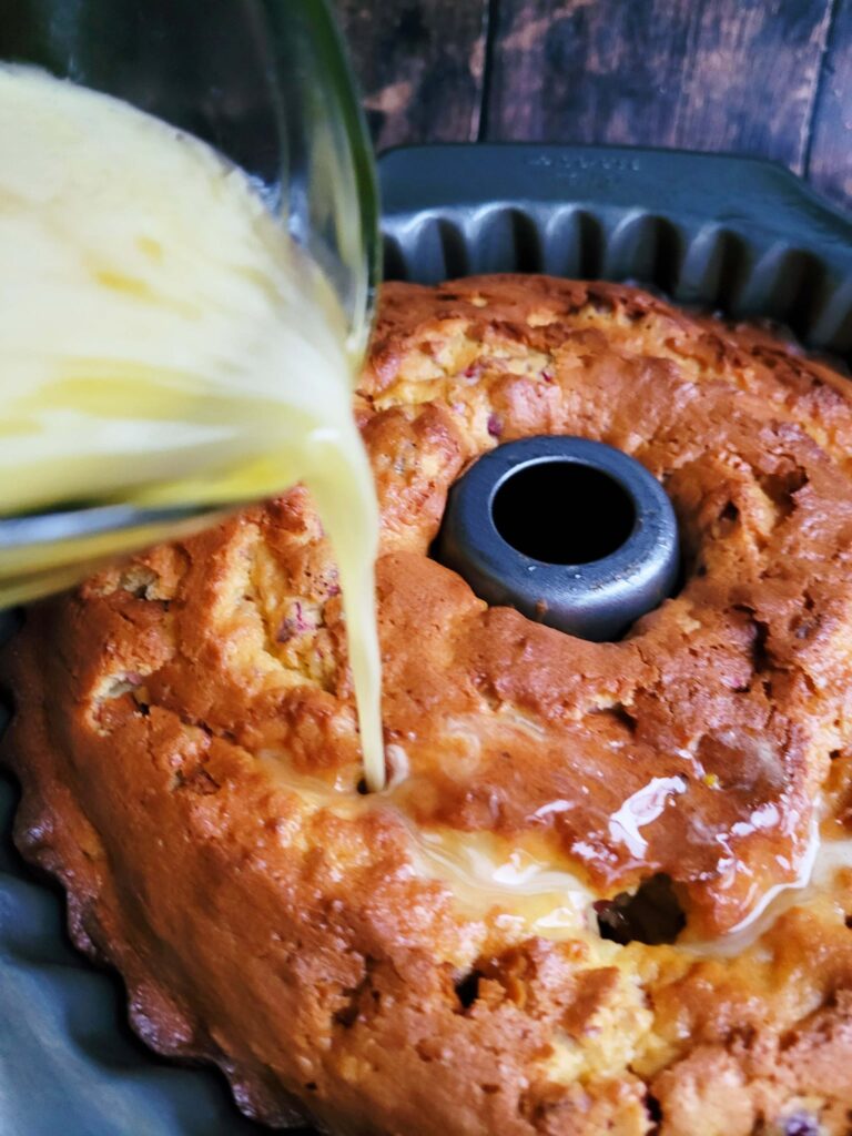 pouring orange butter into upside-down cranberry cake