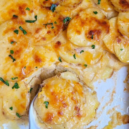 Cheesy Scalloped Potatoes are the ultimate easy classic side dish of perfectly cooked sliced potatoes layered in a creamy cheese sauce and baked crisp in the oven. These home-cooked cheesy scalloped potatoes are easy to make ahead of time, come out perfect every time and are a must-have when it comes to holiday side dishes.