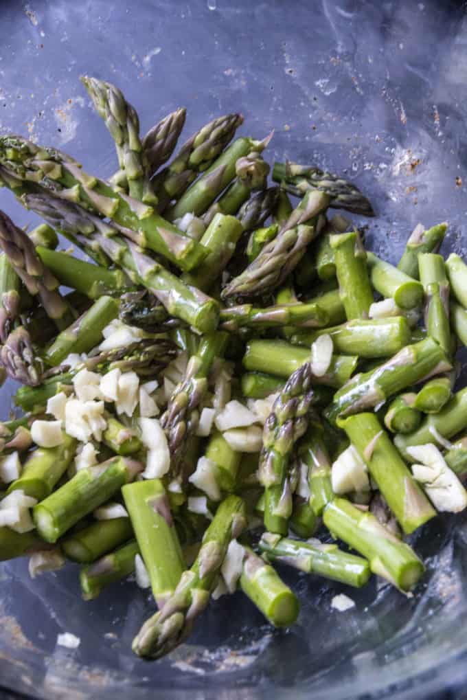 asparagus in a bowl with garlic and butter