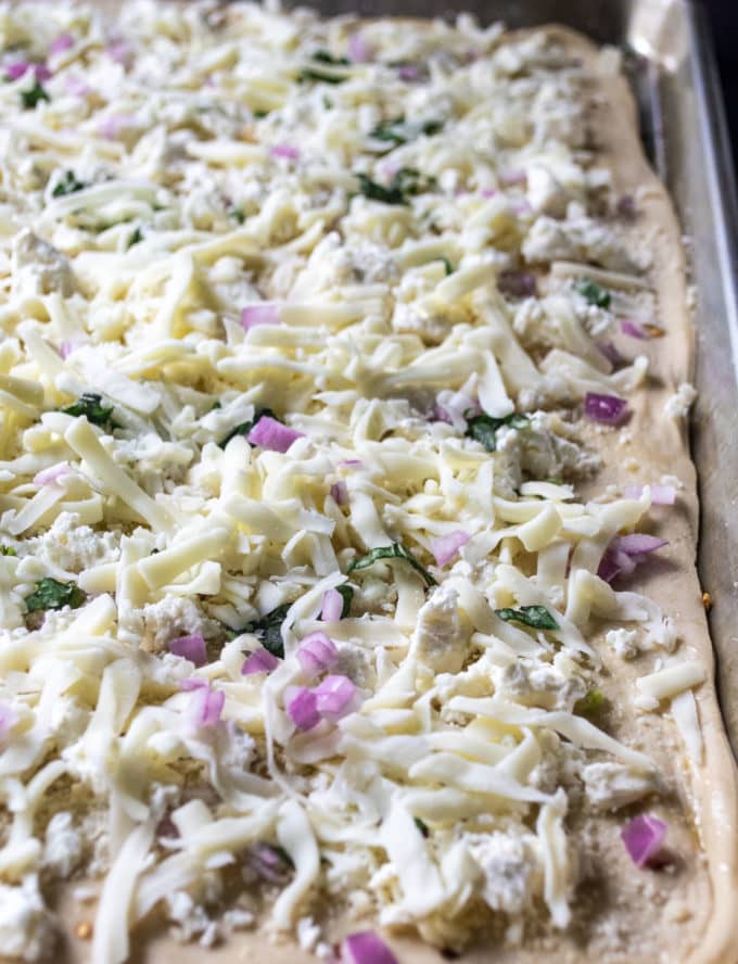 white garlic pizza assembled and ready to bake