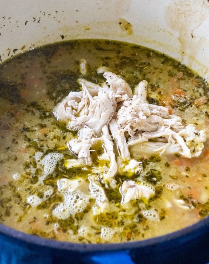 adding shredded chicken to chicken soup pot