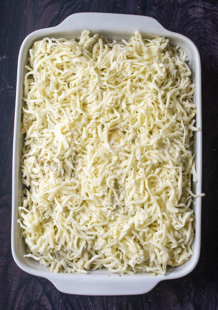 pan of pesto chicken pasta covered in cheese