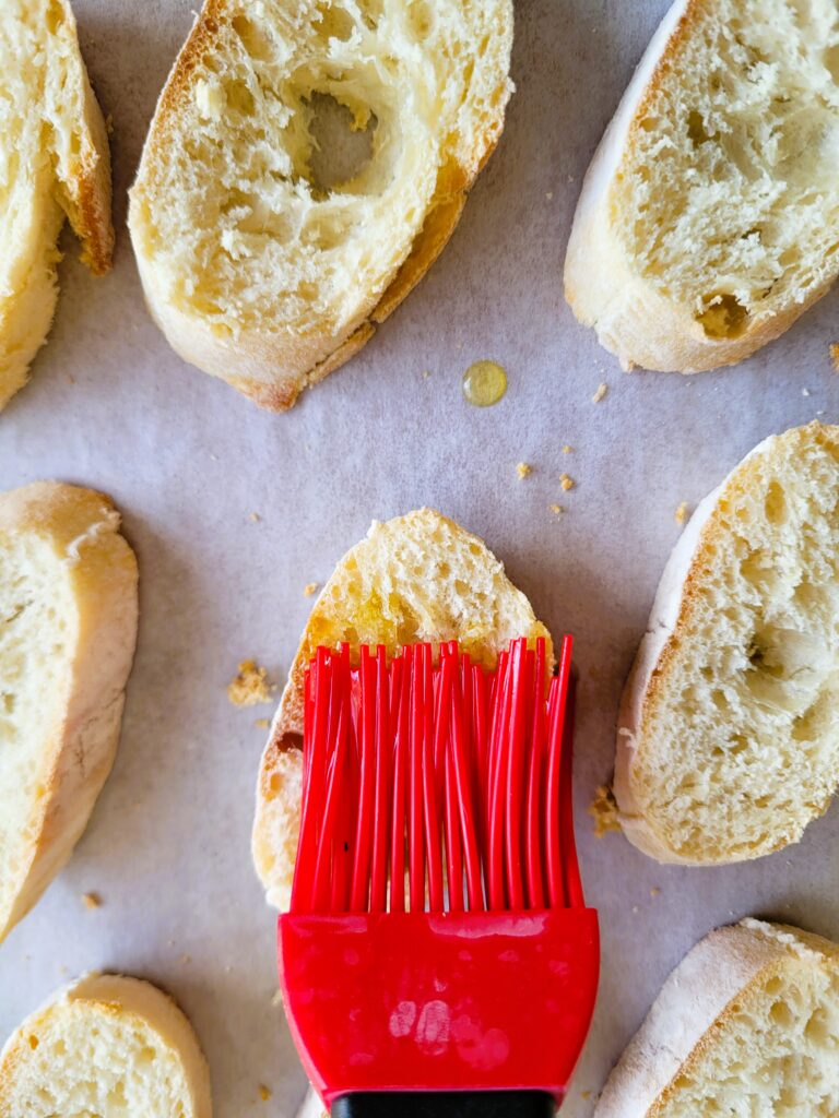 brushing bread slices with olive oil