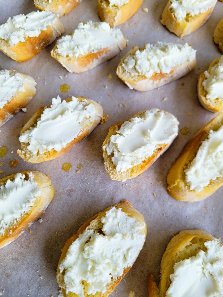 adding goat cheese to baked bread