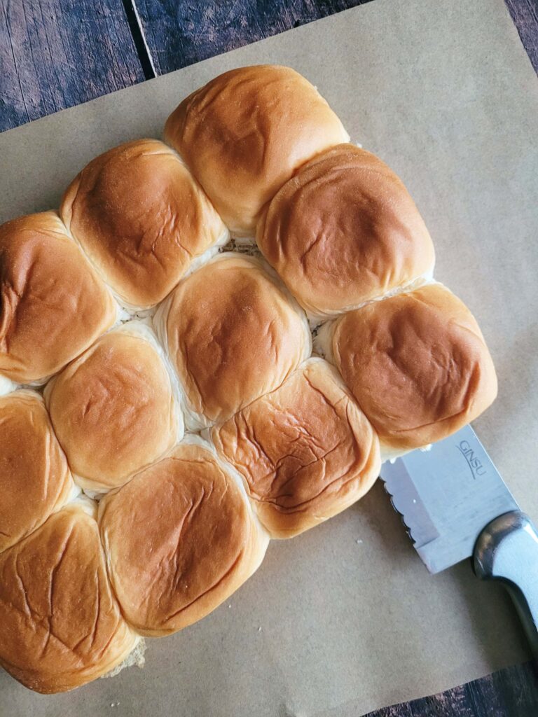 cutting hawaiian rolls in half for ham and cheese sliders