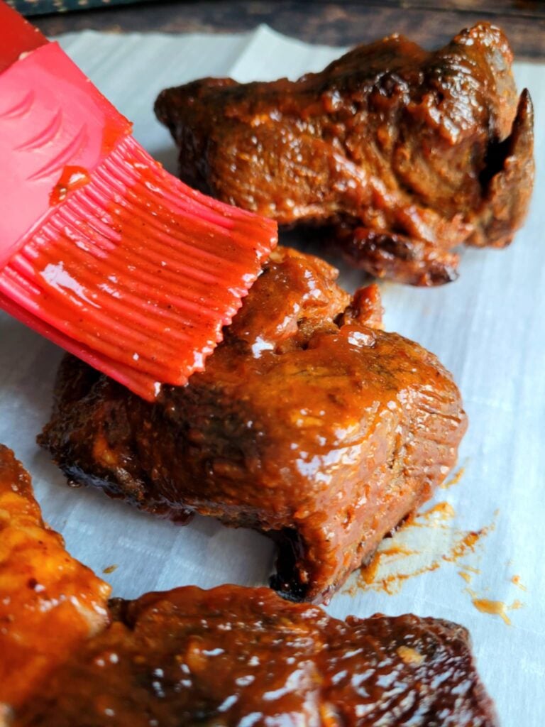 adding bbq sauce to baked ribs