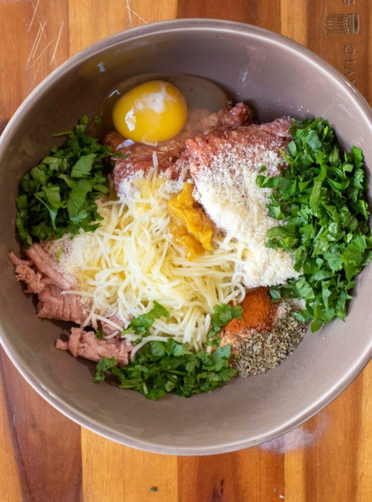 ingredients to make turkey and italian sausage meatballs in a bowl