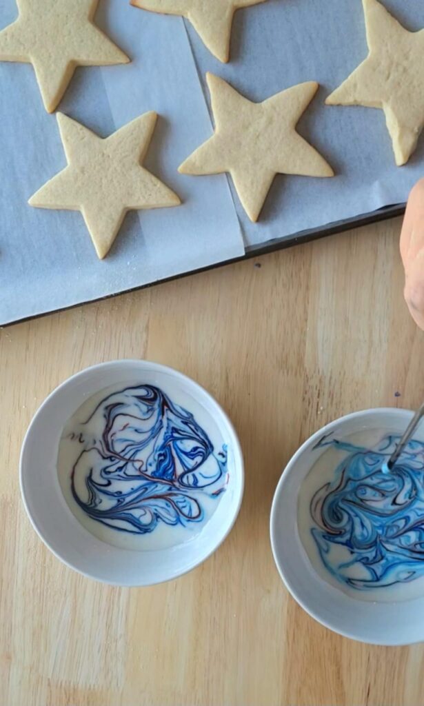 red white and blue swirled royal icing for star cut out sugar cookies