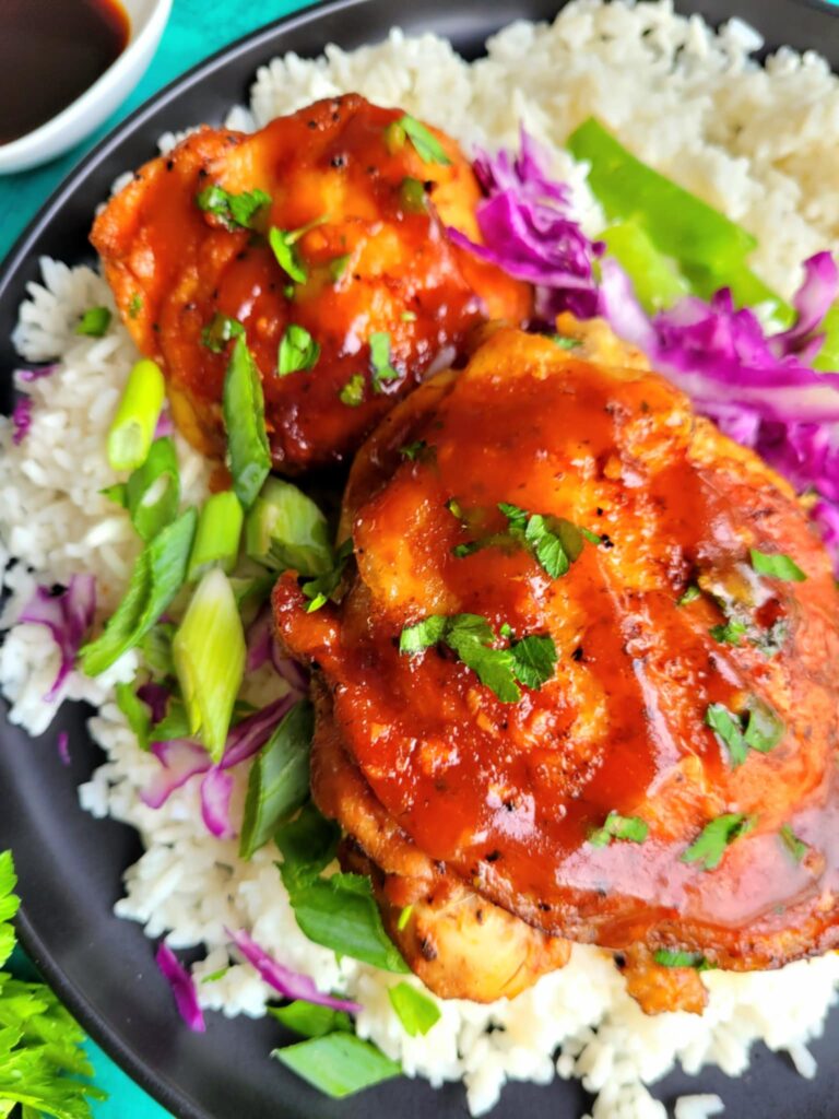 plate of asian inspired chicken thighs over rice
