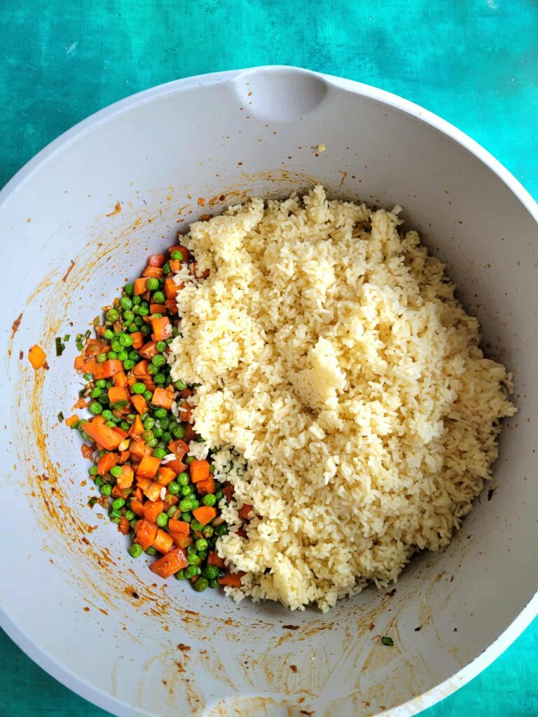 adding day old cooked rice to veggies for fried rice