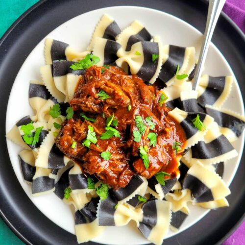 Black & White Pasta with Red Pepper Chile Colorado Beef Sauce is a Tim Burton–inspired Halloween pasta recipe featuring black and white striped bowties tossed in a rich roasted red pepper and Chile Colorado beef sauce. Bold, spooky, and perfect for festive October dinners!