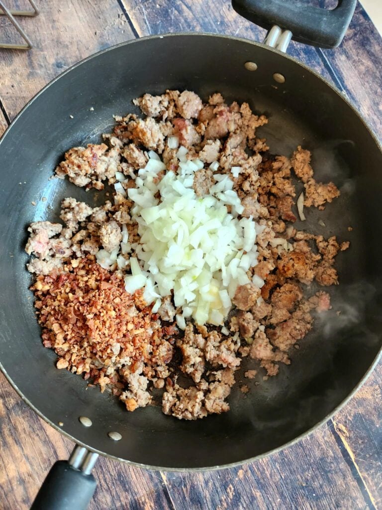 Diced onion and pre-cooked bacon added to browned sausage, sautéing to soften and bring bacon to life.