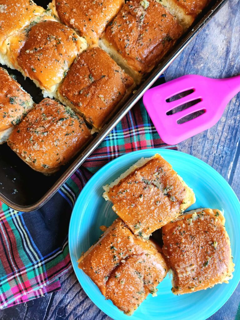 Pull-apart view of soft garlic butter rolls with parsley sprinkled on top.