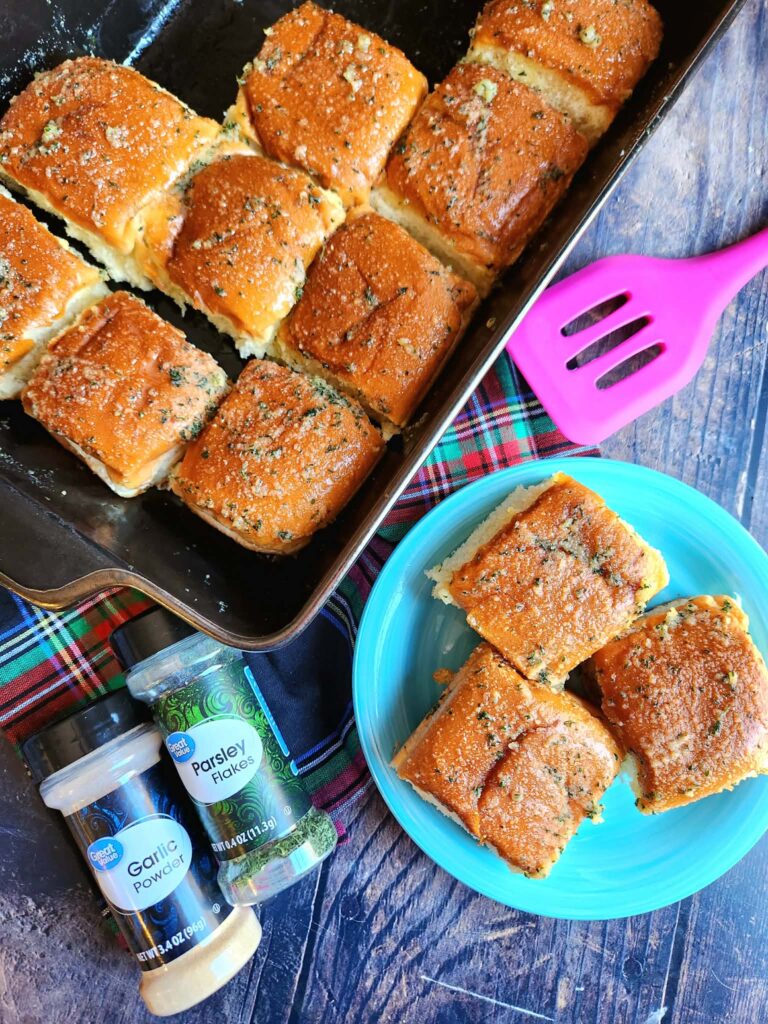 garlic dinner rolls on a plate with garlic powder and parsley