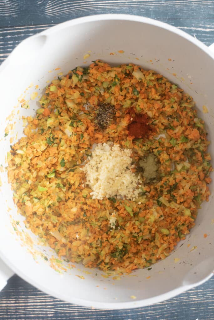 Diced carrots, celery, and onion cooking in bacon fat for ham and bean soup