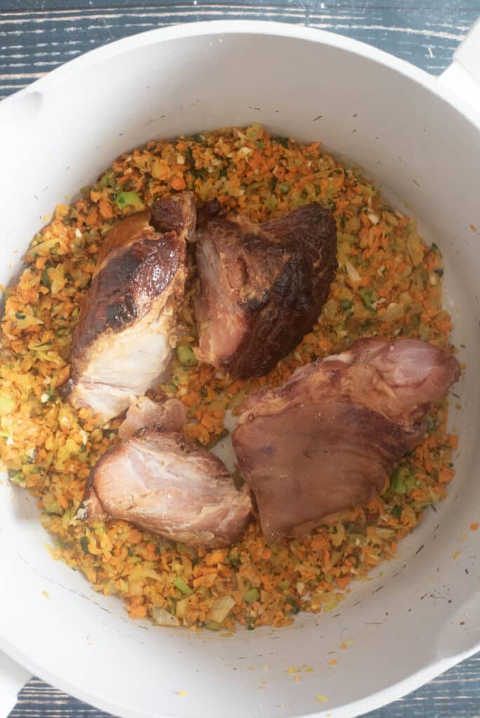 Adding ham hocks and ham bone to simmering white bean soup