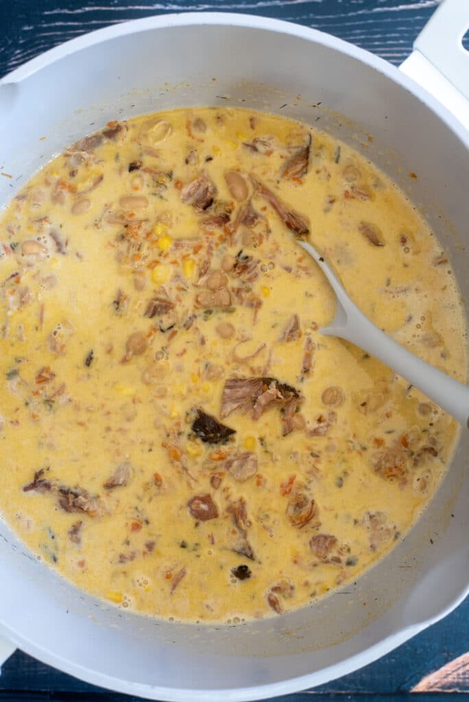 Stirring cream into finished ham and bean soup