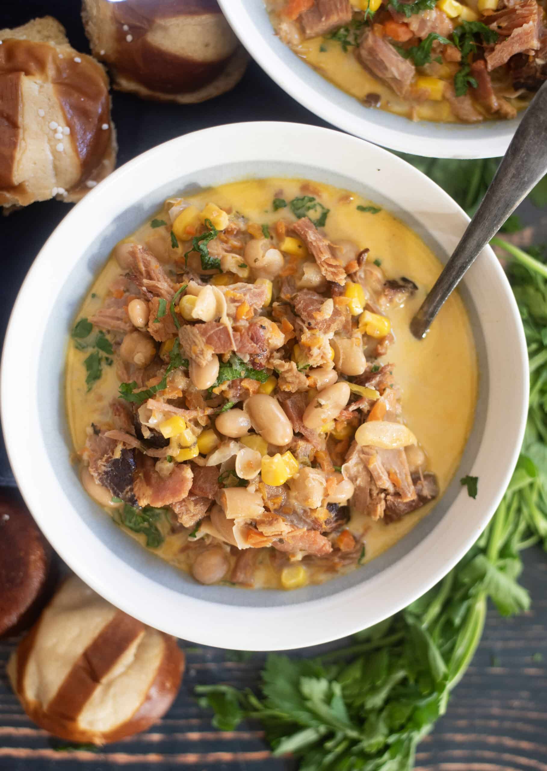 Creamy ham white bean soup in rustic bowl with parsley garnish and crusty bread