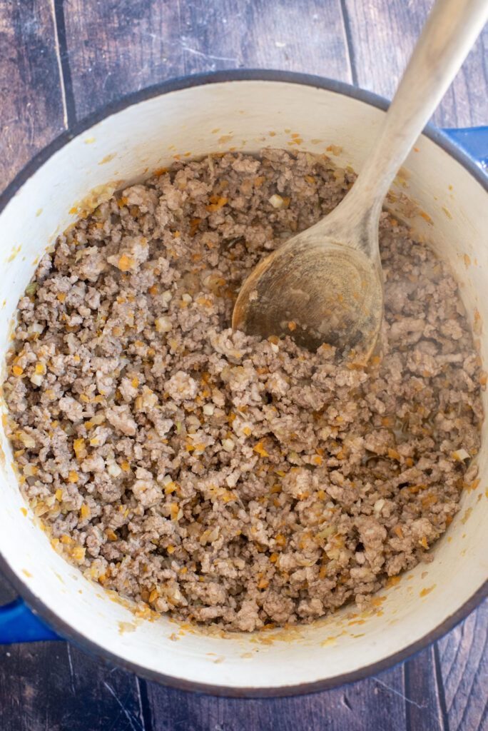 Browning ground beef and pork for rich homemade bolognese sauce in a large skillet