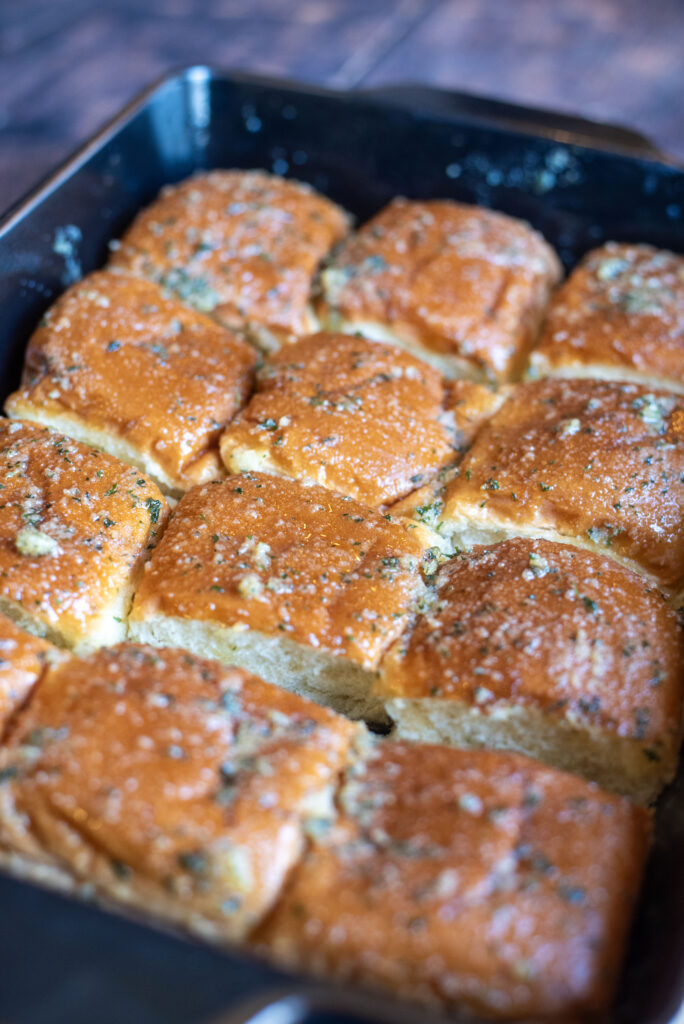 brushing second layer of garlic butter on rolls fresh out of the oven.