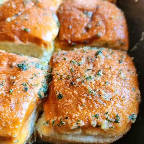 Fully baked 10 minute garlic dinner rolls in baking dish, golden and glossy.
