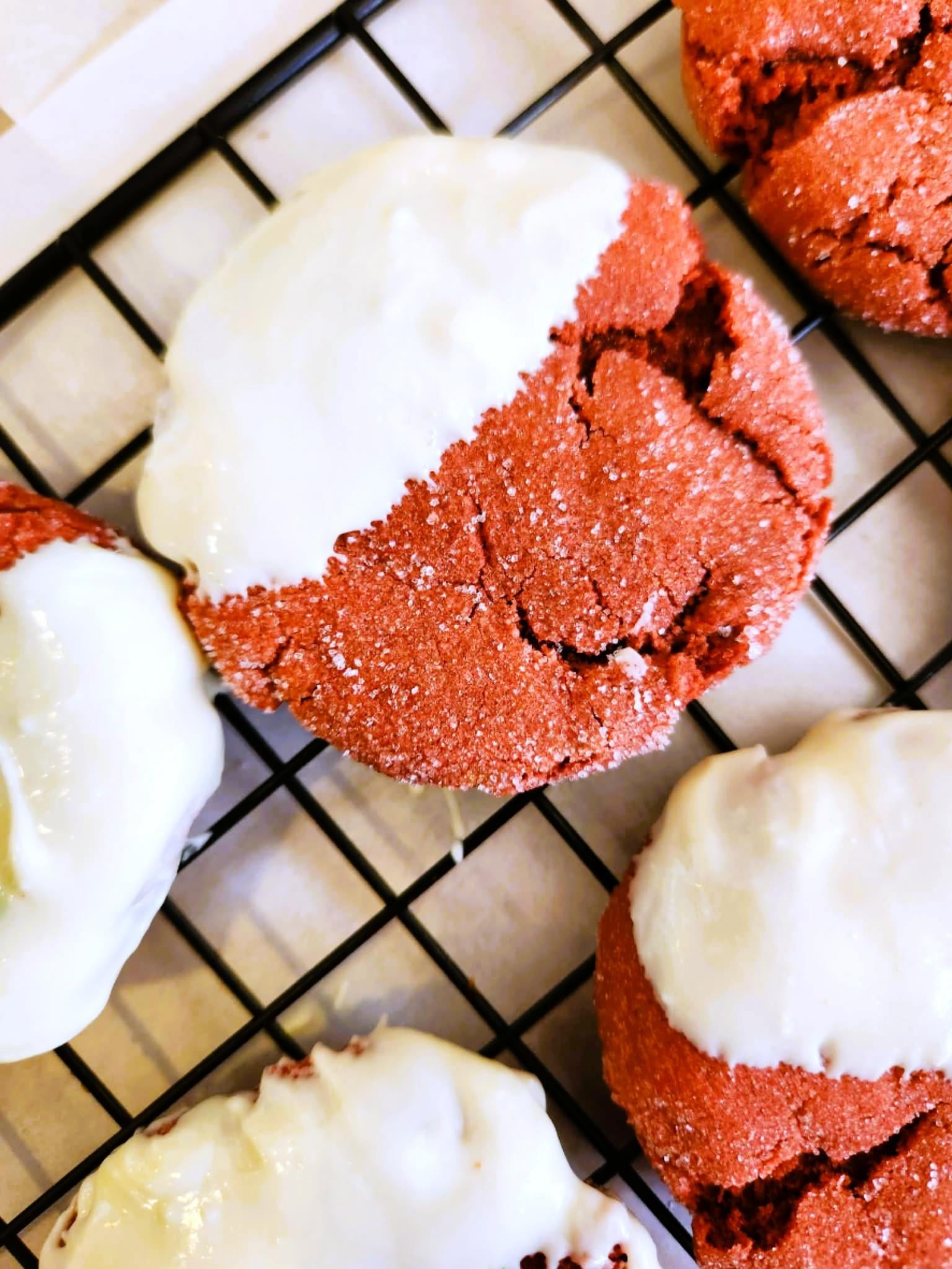 Close-up of chewy red velvet cookies with sugar-crackled edges and creamy white chocolate dip.