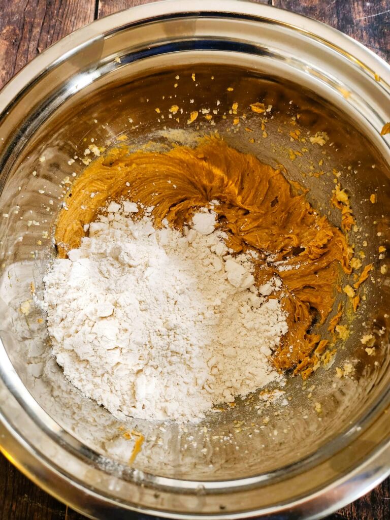 adding dry ingredients to wet cookie dough ingredients