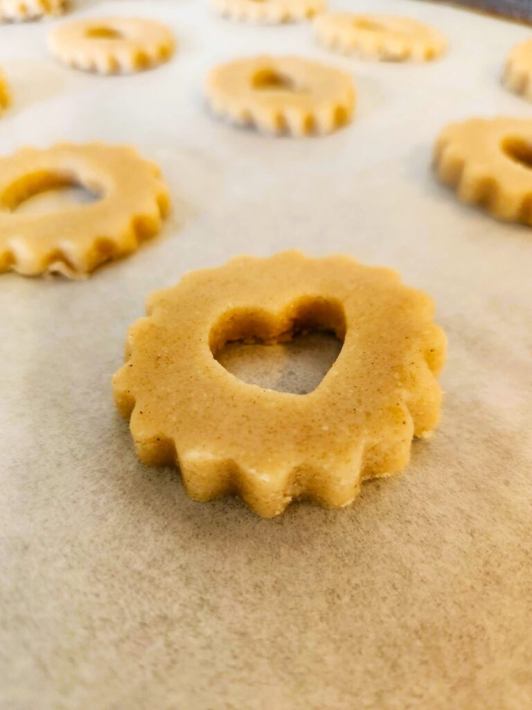 Baking Linzer sandwich cookies on a parchment-lined sheet tray.