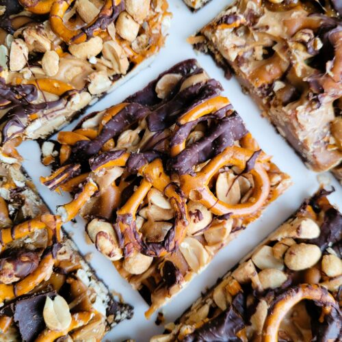 Finished five-layer chocolate peanut butter bars sprinkled with flaky salt, perfect for snack-time indulgence