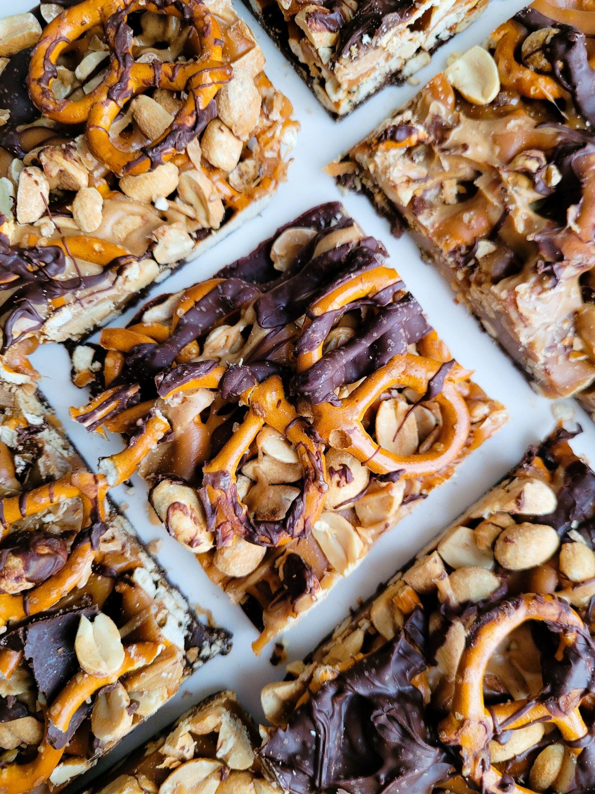 Finished five-layer chocolate peanut butter bars sprinkled with flaky salt, perfect for snack-time indulgence