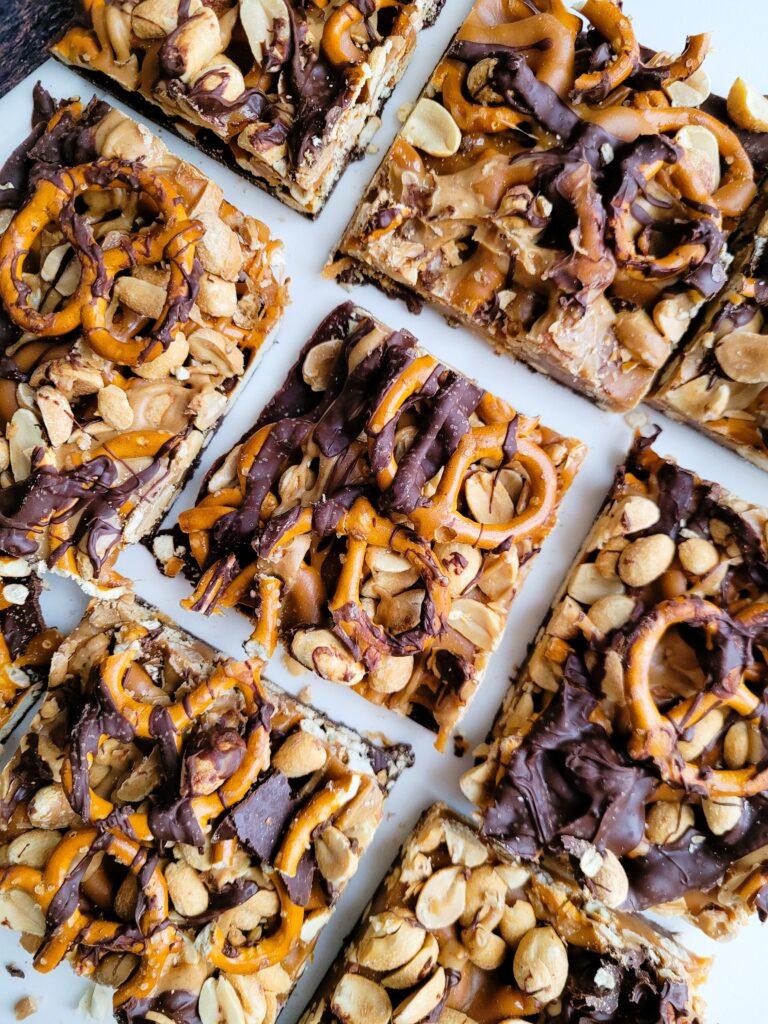 Tray of fully set DIY peanut butter chocolate caramel bars ready to cut into squares
