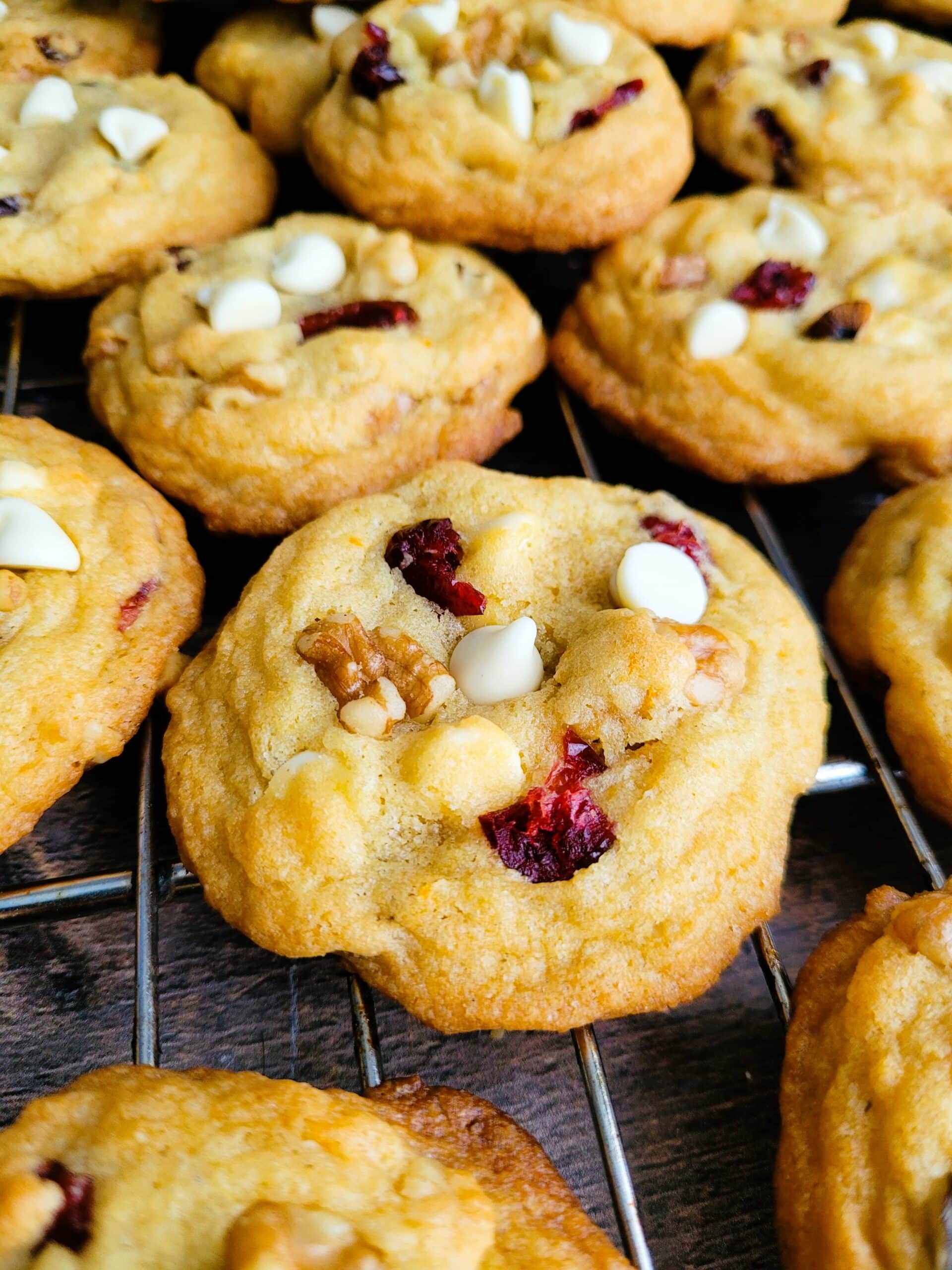 soft-baked cranberry orange white chocolate chip cookie revealing chewy center and white chocolate chunks
