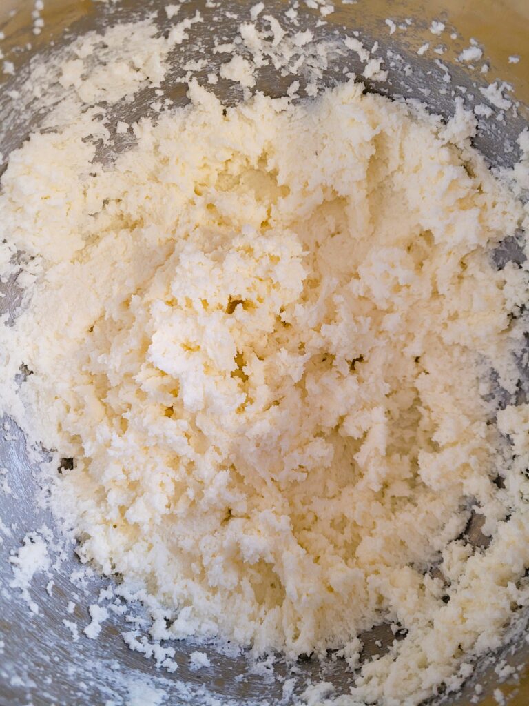Mixing softened butter, sugar, egg, and vanilla for no-chill sugar cookie dough in a mixing bowl