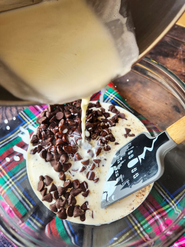 Pouring hot cream over semisweet chocolate chips to make glossy peppermint mocha ganache.